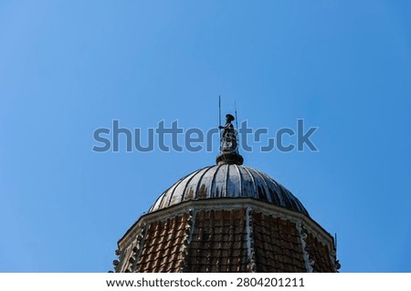 Spire featuring a bronze statue of John the Baptist,Baptistery of San Giovanni, the Cathedral's baptismal church on Piazza del Duomo – the Cathedral Square, unofficially known as Piazza dei Miracoli – in Pisa, Tuscany, Italy.