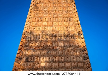 The spire of the pagoda, with its truncated triangular top, is adorned with neatly arranged tiles, creating a beautiful sight on a clear day