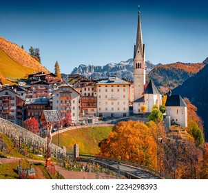 Spire of Parrocchia di San Giacomo Maggiore Catholic church on deep blue sky background. Colorful autumn cityscape of Pieve village, Province of Belluno. Travel to Italy.