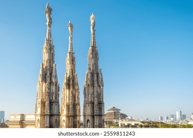 Spires of Gothic cathedral Duomo di Milano with statues and ornate decorations against clear blue sky and modern city skyline, Milan, Lombardia, Italy. Close up - Powered by Shutterstock