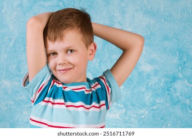 A spirited boy strikes a playful pose with his arms raised, exuding happiness against a bright blue backdrop, capturing the essence of childhood joy and spontaneity. - Powered by Shutterstock