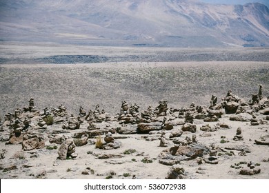 Spiritual apachetas (stone cairns) scattered along the trail between Arequipa and Chivay in Colca Canyon area, Peru. These piles of rocks are believed to bring good luck and protection in the Andes.