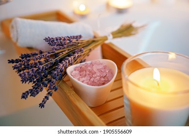 Spiritual aura cleansing ritual bath for full moon ritual. Candles, aroma salt and lavender on tub table, close up - Powered by Shutterstock