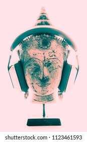 Spiritual Music Therapy. Contemporary Image Of Buddha Head With Modern Headphones Representing Religious, New Age, Or Trance Music. Divine Pink White Light Background For Purity And Enlightenment.