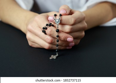 Spiritual prayer to god, with verve or rosary in the hands of a young girl. Black background. Close-up. - Shutterstock ID 1852737115