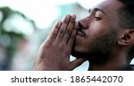 Spiritual young black African man praying to GOD. Person looking to sky with HOPE and FAITH