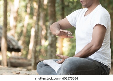 Spiritual Young man practicing traditional Tai Chi Chuan, Tai Ji  and Qi gong in the park for healthy, traditional chinese martial arts concept.