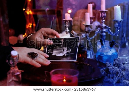 spiritualistic seance in salon of medium with old photographs of deceased relatives, Female Fortuneteller or esoteric Oracle, longing for ancestors, communication with world spirits, help of ancestors