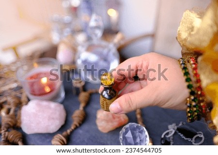 spiritualistic session in salon of soothsayer, fortune-teller, hands of female medium, alchemist, herbalist hold witchcraft potion, poison, elixir of youth, burning candles, spells, ritual magic