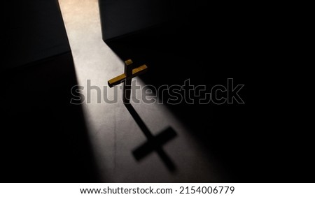 Spirituality, Hopefulness and Religion Concept. Wooden Christian Cross. Light Shading from the Opening Door. Symbol of Humility, Supplication,Believe and Faith for Christian People