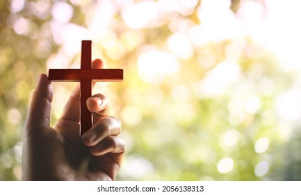 Spirituality and Religion Concept, Person Holding Christian Cross to Making Pray Outdoors. Believe and Faith for Christian People - Shutterstock ID 2056138313