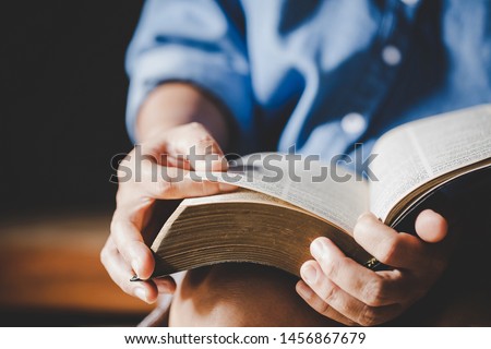 Spirituality and religion, Hands folded in prayer on a Holy Bible in church concept for faith.
