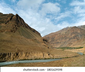 Spiti Fluss fließt im Spiti-Tal durch Himalaya Berge mit Tabo-Stadt nur sichtbar in der Ferne unter blauem Himmel nahe Tabo, Himachal Pradesh, Indien.