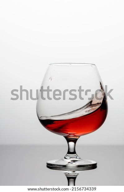 Splash of\
brandy in a snifter glass. Copy\
space.