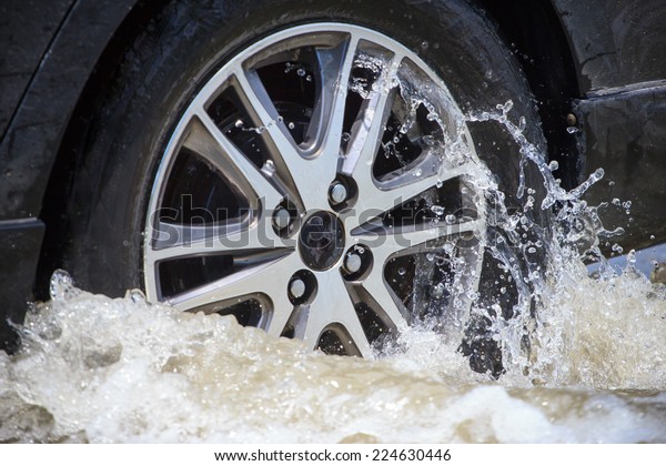 Splash by a car\
as it goes through flood\
water