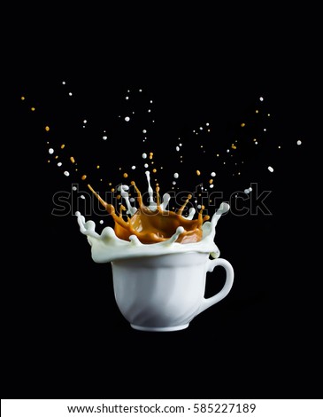 Splash of coffee and milk in white cup isolated on black background movement action