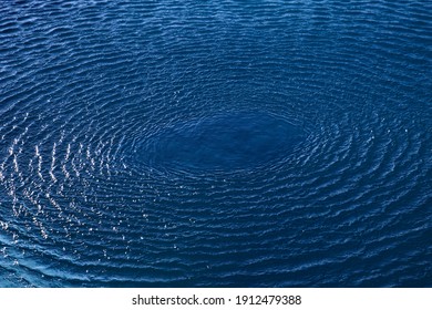 Splash: Concentric Circle Waves On Blue Fresh Sea Water; Color Photo.