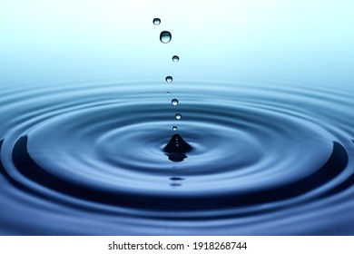 Splash. Rain drops falling on smooth surface of water