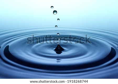 Splash. Rain drops falling on smooth surface of water