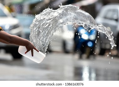 Splash stream from a white plastic  water bowl in Songkran festival, Thailand