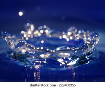 Splash Of Wather On Blue Background. Water Symbol.