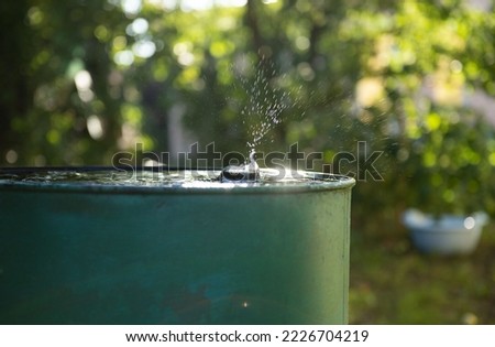 Splashes from falling drops into a barrel of water