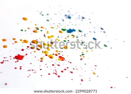 Splashes of paint on a white background. Colored spots of paint on a white background. There are many drops of colored paint on white paper.