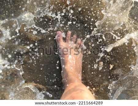splashes of sea water and the foot of the person who stepped on it
