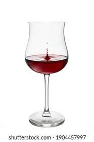 Splashing in glass. Red wine in wineglass isolated on white background. Drop falls into glass and creates splash and wave on surface of red wine