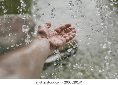 Splashing Water Falling On A Man's Hand From A Waterfall.