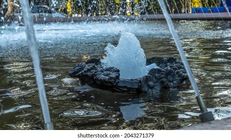 Splashing Water In The Fountain At Summer City Public Urban Park. Water Jets Abstract Image Close-up. Thin Jets Of Pure Clear Aqua Splashes Flying Upwards Under Pressure.