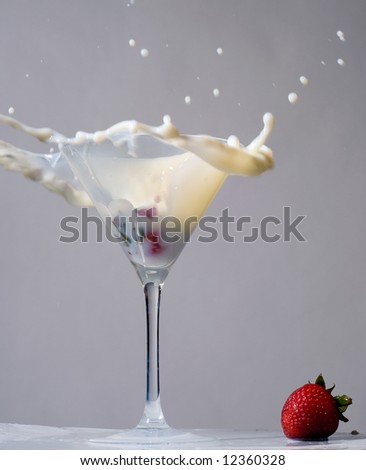 splashing wet strawberry in martini glass
