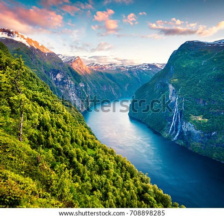 Splendid summer sunset of Sunnylvsfjorden fjord canyon, Geiranger village location, western Norway. Aerial evening view of famous Seven Sisters waterfalls. Beauty of nature concept background.