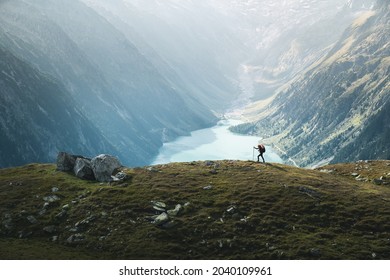 Splending view of a female climber hiking over mountain ridge against blue,turquoise lake in Zillertal Alps ,Austria. Young woman walking on the edge of mountain. Travel, adventure, lifestyle, hiking - Powered by Shutterstock