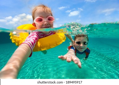 Split above and underwater photo of adorable kids having fun swimming on summer vacation
