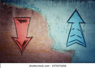 Split concrete wall cracked in the middle and arrows going in two different ways on red and blue side. Correct choice between up and down, failure or success. Difficult decision and doubt concept.