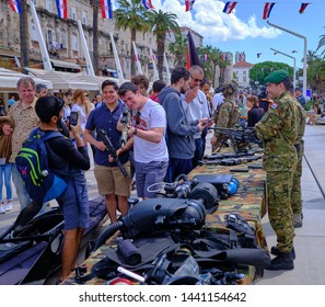 Split, Croatia - April 27, 2019. Croatian Military Exhibition. Man Picking Up Weapon On Display To Pose For Picture