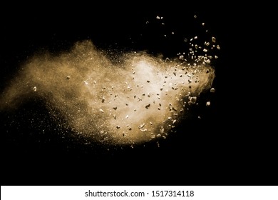 Split Debris Of Brown Stone Exploding With Brown Powder Against Black Background.