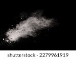 Split debris of  stone exploding with white powder against black background.