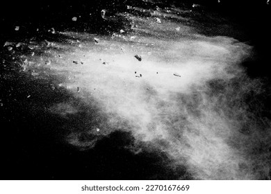 Split debris of  stone exploding with white powder against black background.