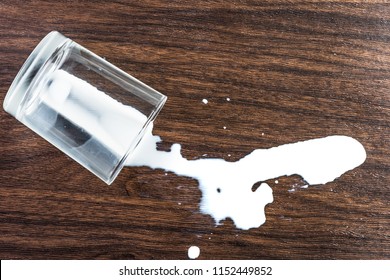 Split Milk From A Glass On Wooden Table, Top View