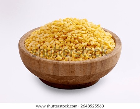 Split Moong beans or yellow lentils in Wooden Bowl isolated on White background