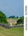 A split rail fence frames monuments and a row of cannon at Antietam Battlefield in Sharpsburg, Maryland, USA.