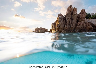 Split shot, over under photo. Half underwater with turquoise water and a rocky coast on the water surface. Prince Beach (Spiaggia del Principe) Sardinia, Italy.