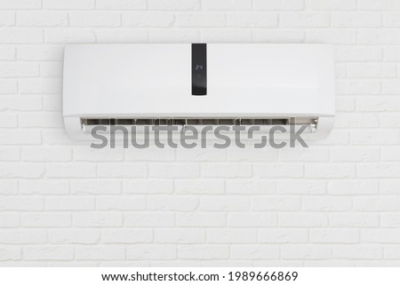 Split system air conditioning unit on decorative white brick wall