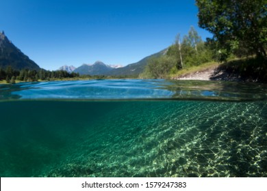 Split View / Half Underwater Shot In Clear Mountain Lake In European Alps / Austria