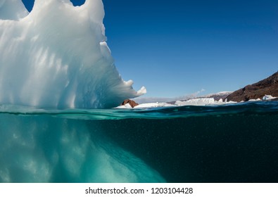 Split View Of An Iceberg Showing Above And Below The Water Line, Eastern Greenland.