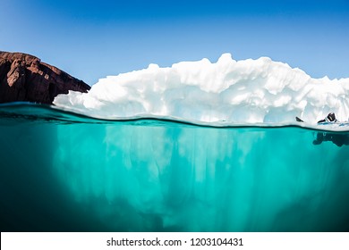 Split View Of An Iceberg Showing Above And Below The Water Line, Eastern Greenland.