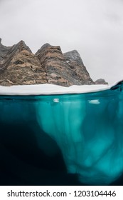 Split View Of An Iceberg Showing Above And Below The Water Line, Eastern Greenland.