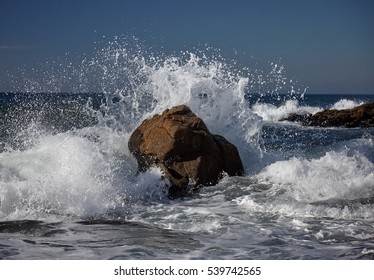 splits waves against rocks in the sea